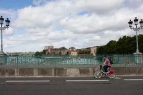 On voit un homme sur un vélô Toulouse en train de pédaler sur le pont Saint-Michel à Toulouse  (Agrandir l'image - fenêtre modale)